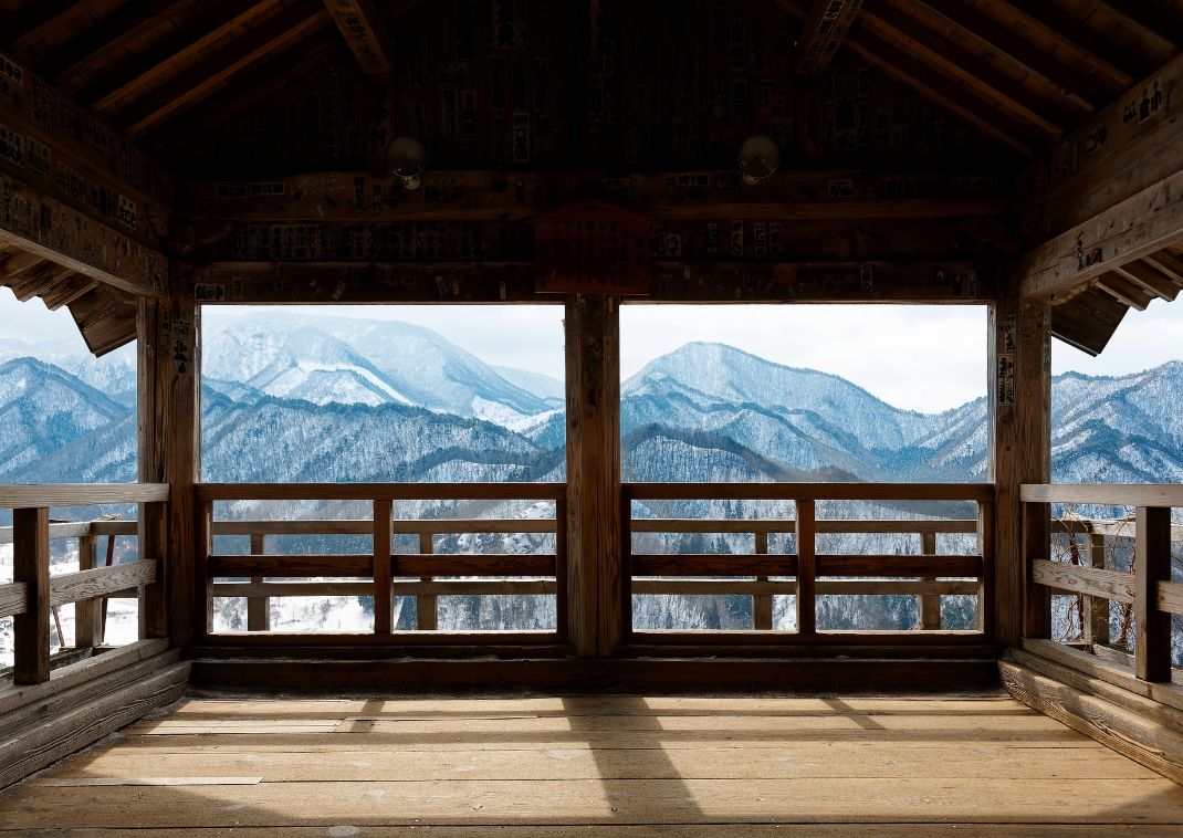 Una vista panorámica que da a las montañas invernales cubiertas de nieve desde el interior del Salón Godaido.

