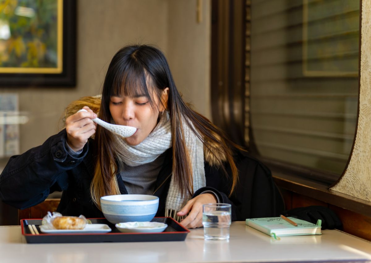 Mujer cenando en un restaurante japonés en invierno
