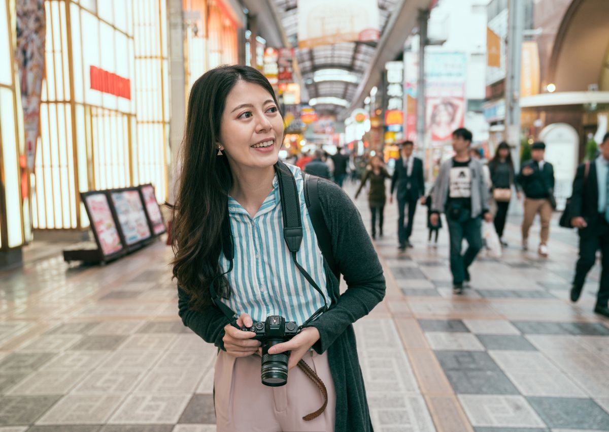 Mujer explorando la calle comercial Tenjinbashisuji, Osaka
