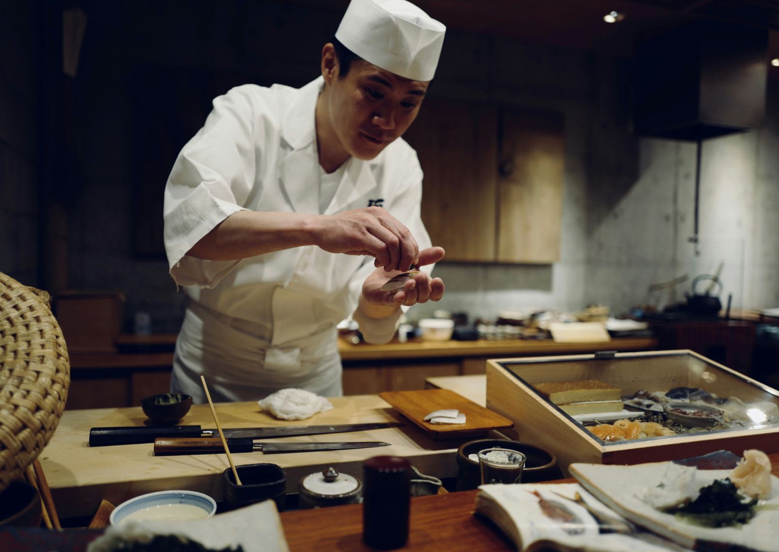 Cocinero japonés manipulando el sashimi