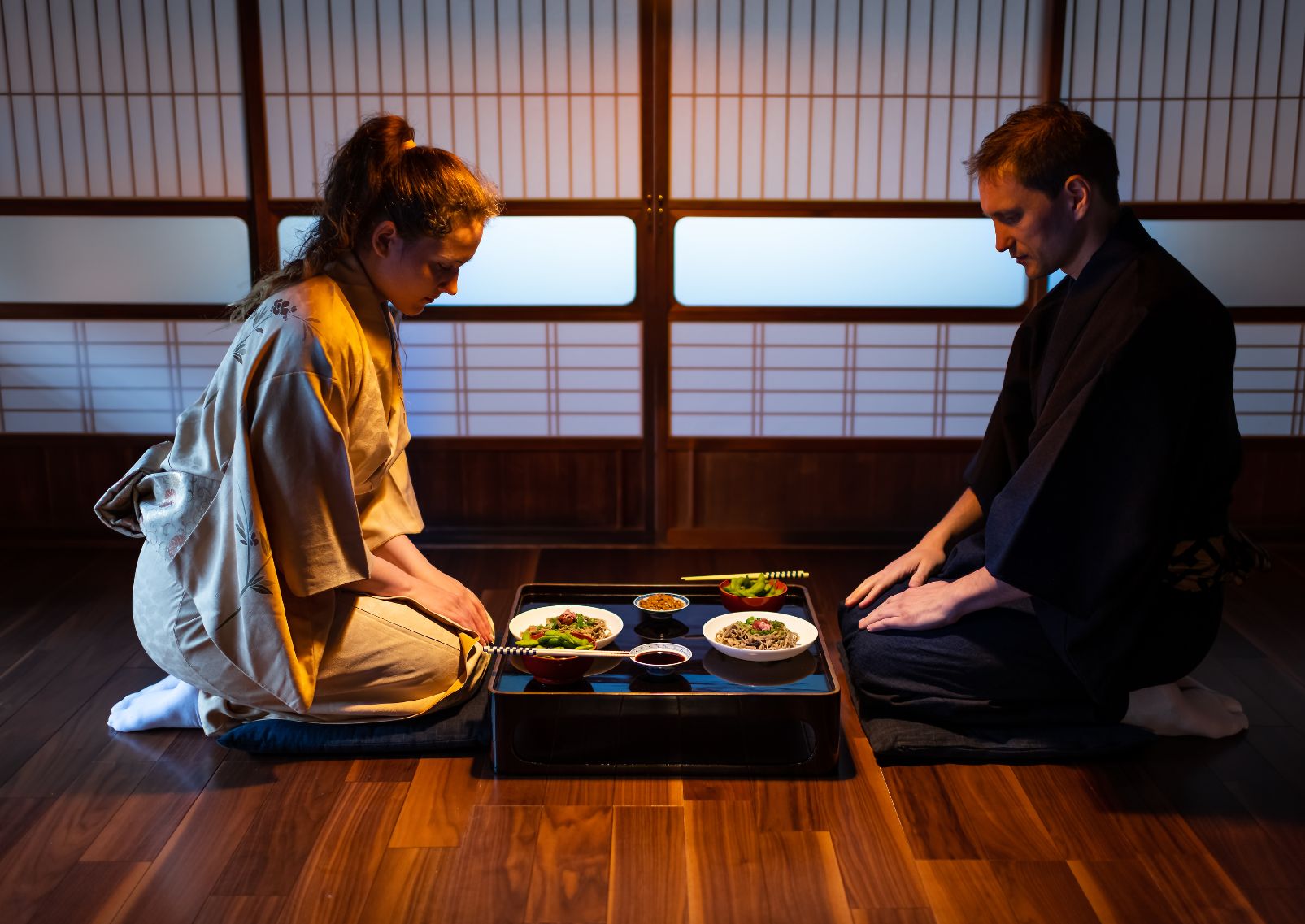 Pareja joven de turistas disfrutando de una experiencia kaiseki en el ryokan