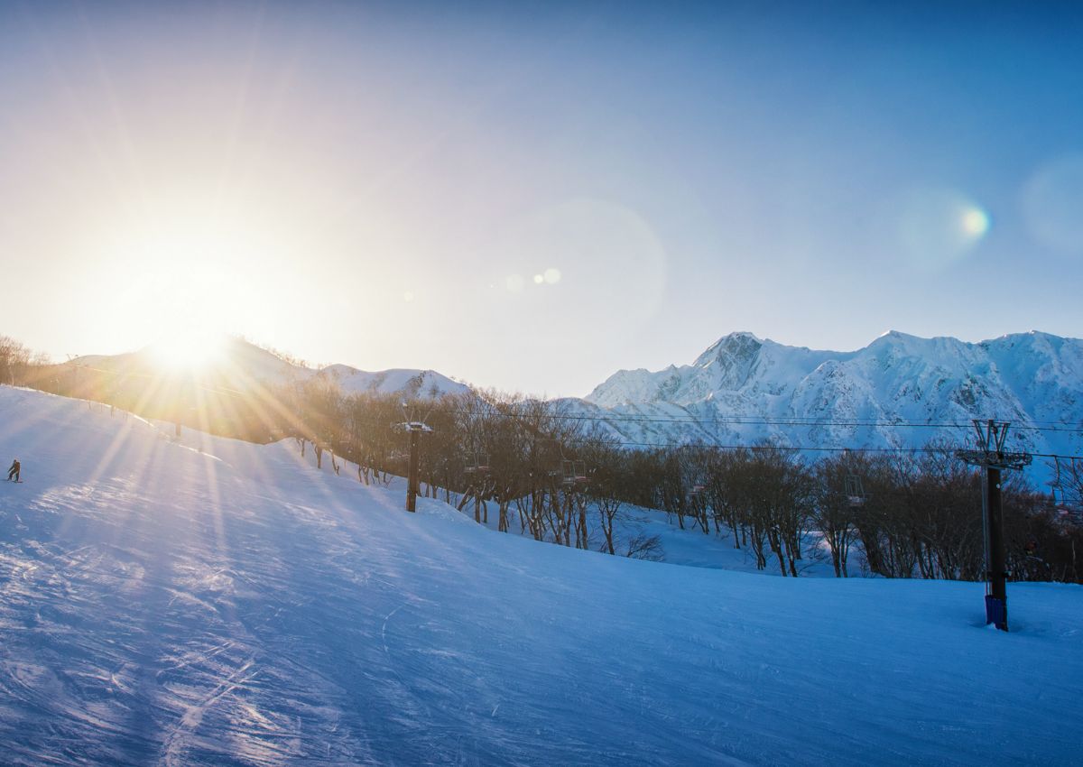 Snowboarder al atardecer en la estación de esquí de Hakuba, Nagano, Japón