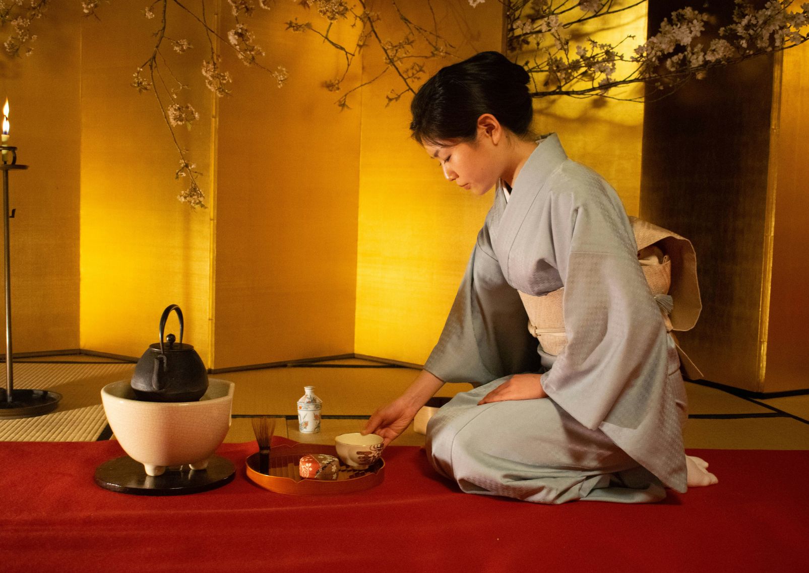 Mujer japonesa realizando la ceremonia del té en kimono