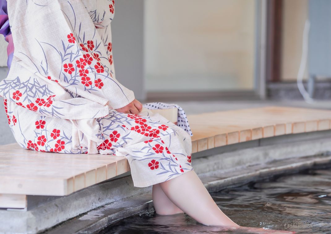 Mujer con yukata japonesa bañándose los pies, Japón.