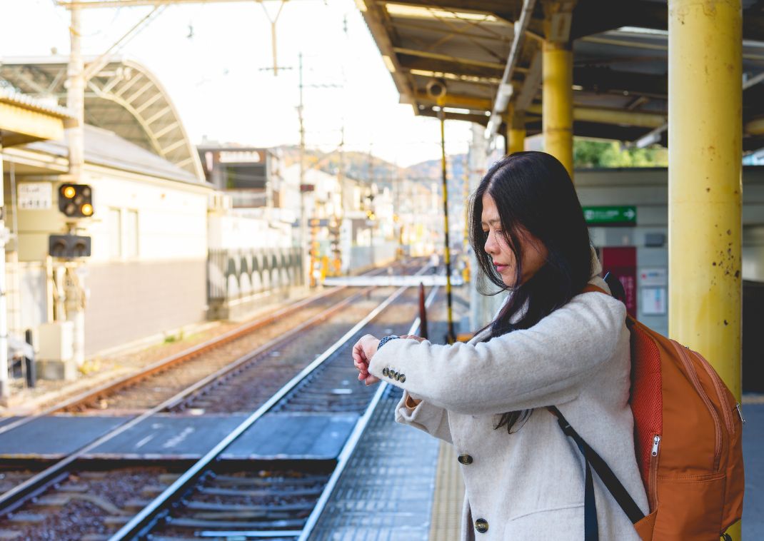 Mujer mirando el reloj en una estación de tren en Japón