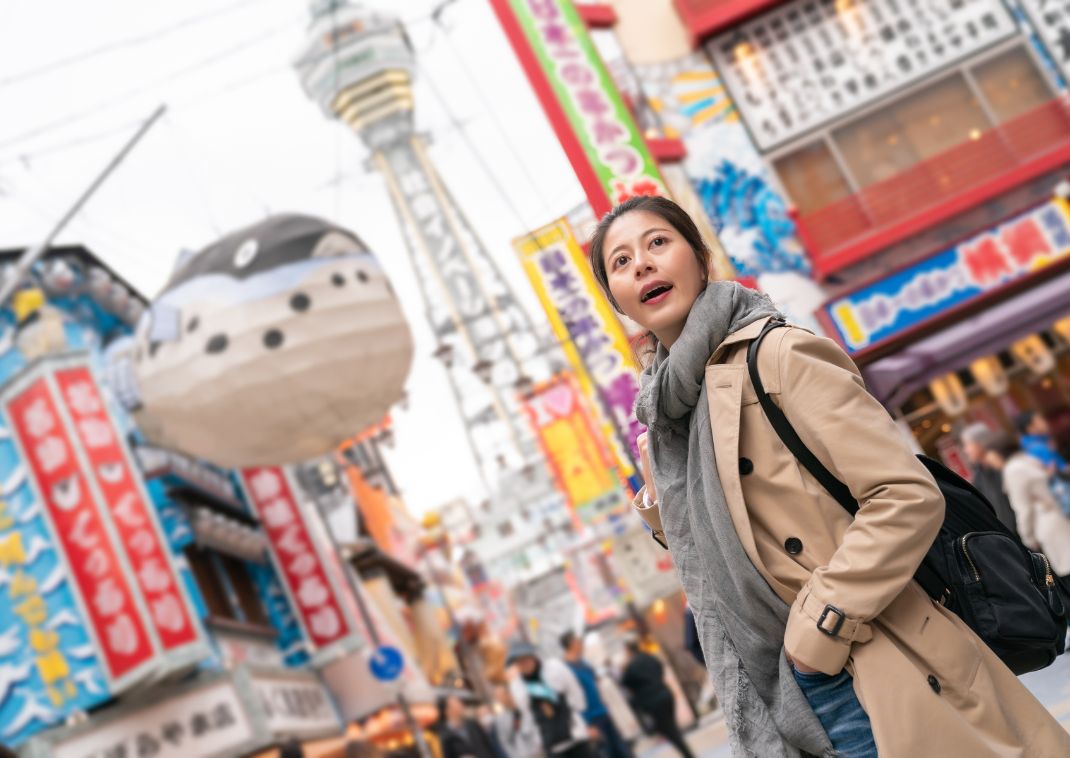 Joven asiática explorando la zona Shinsekai de Osaka