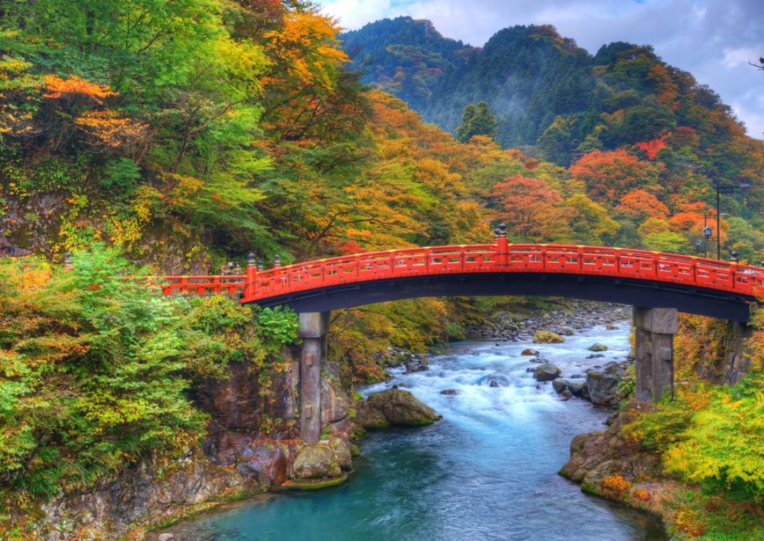 Puente rojo en contraste con el follaje de otoño en Nikko, Japón, en otoño