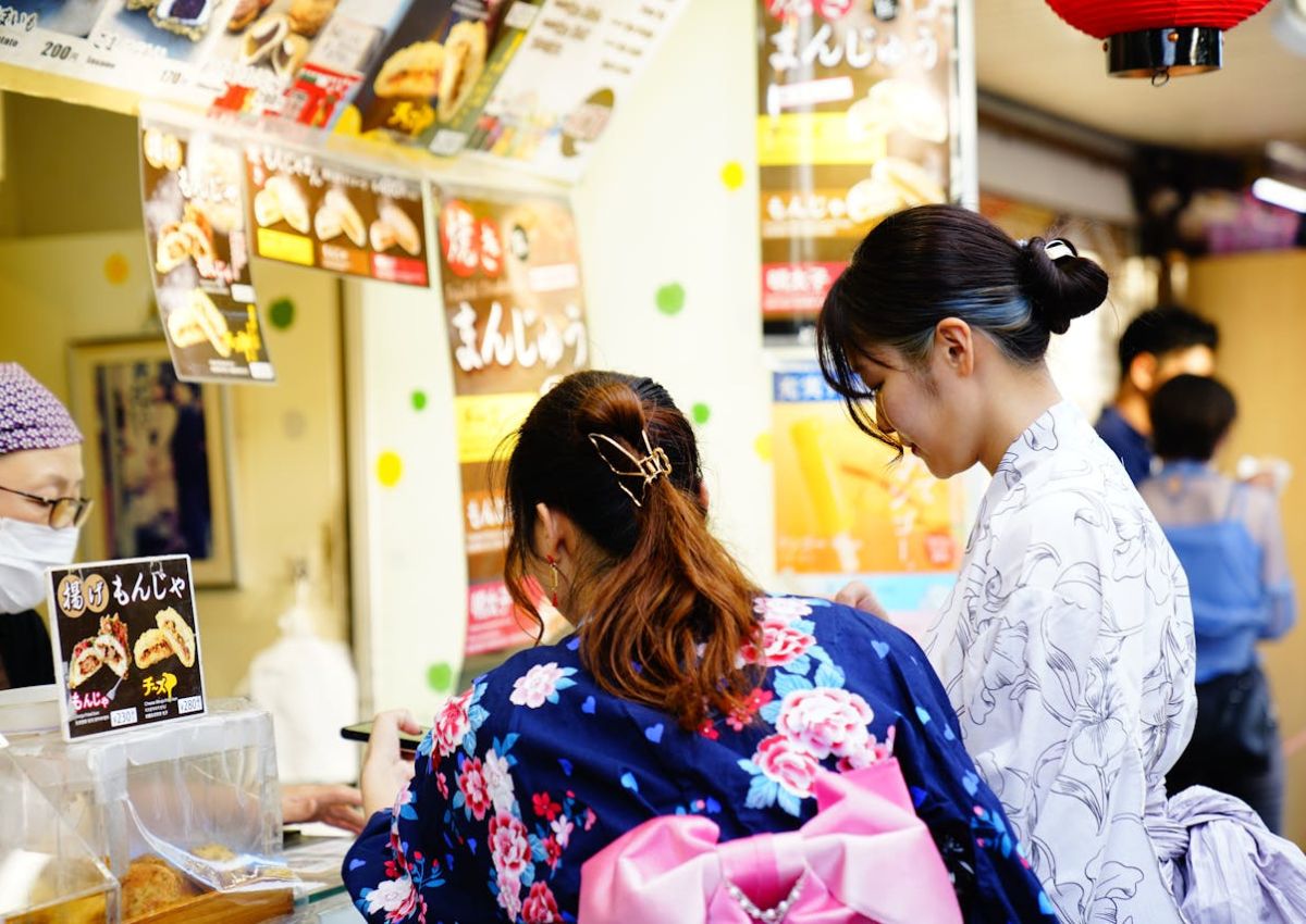 Mujeres en Yukata comprando en un puesto de comida