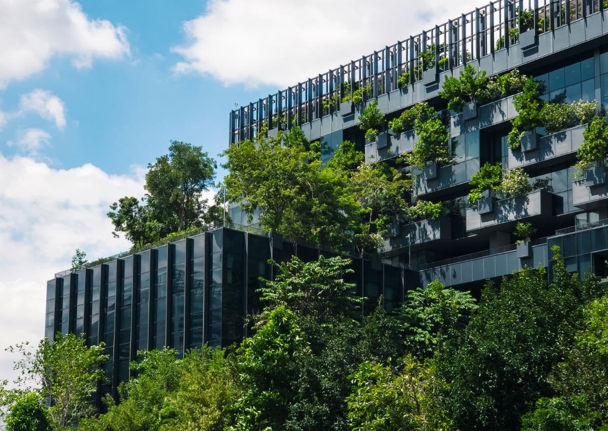 Edificio ecológico sostenible: diseño de fachada de cristal respetuoso con el medio ambiente, con árboles; concepto de ecología, salud y bienestar