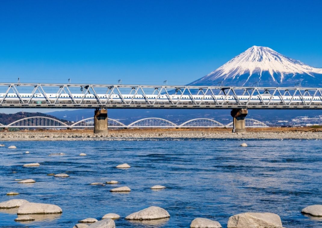 Tren bala en Japón pasando a gran velocidad con el Monte Fuji de fondo.