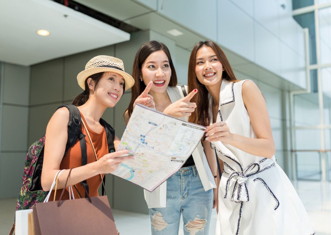 Mujer sosteniendo un mapa que muestra a otras dos mujeres adónde ir en Japón.