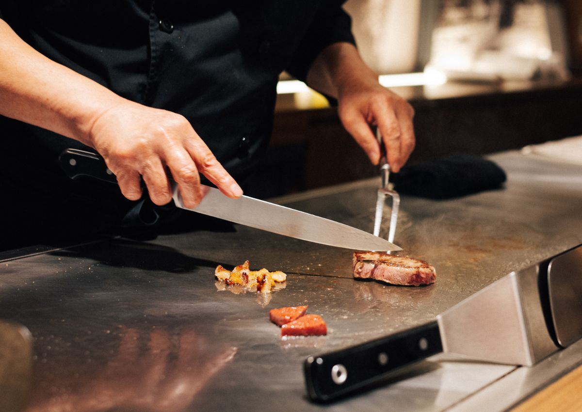Chef cortando un filete de carne de res Kobe en una parrilla teppanyaki