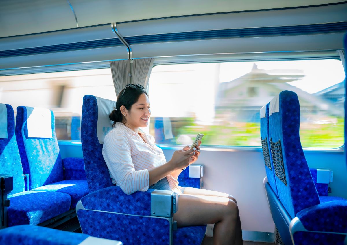 Una turista sonriente sentada en un Shinkansen en Japón