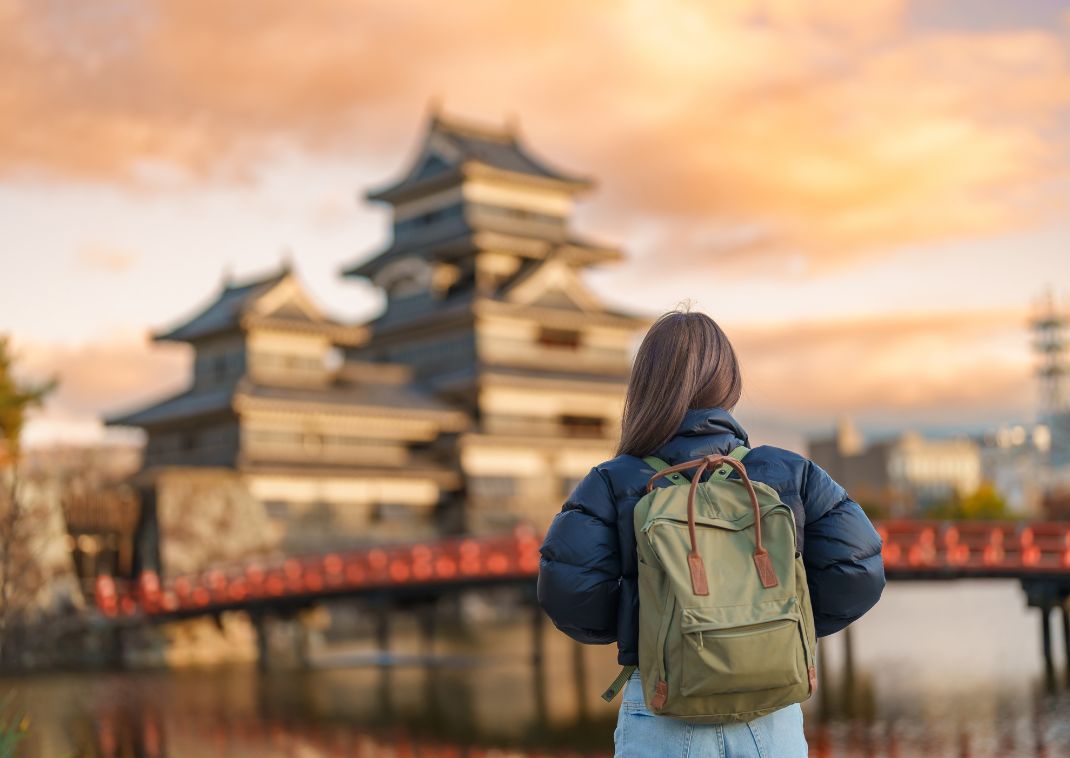 Mujer mirando el castillo de Matsumoto en Japón