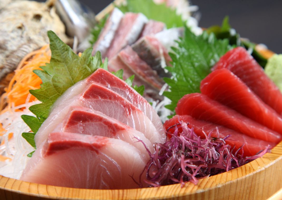 Sashimi fresco japonés en un cuenco de madera