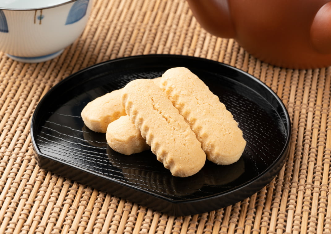 4 Gastronomía de Okinawa. Snack de galletas sobre un plato negro. Japón.