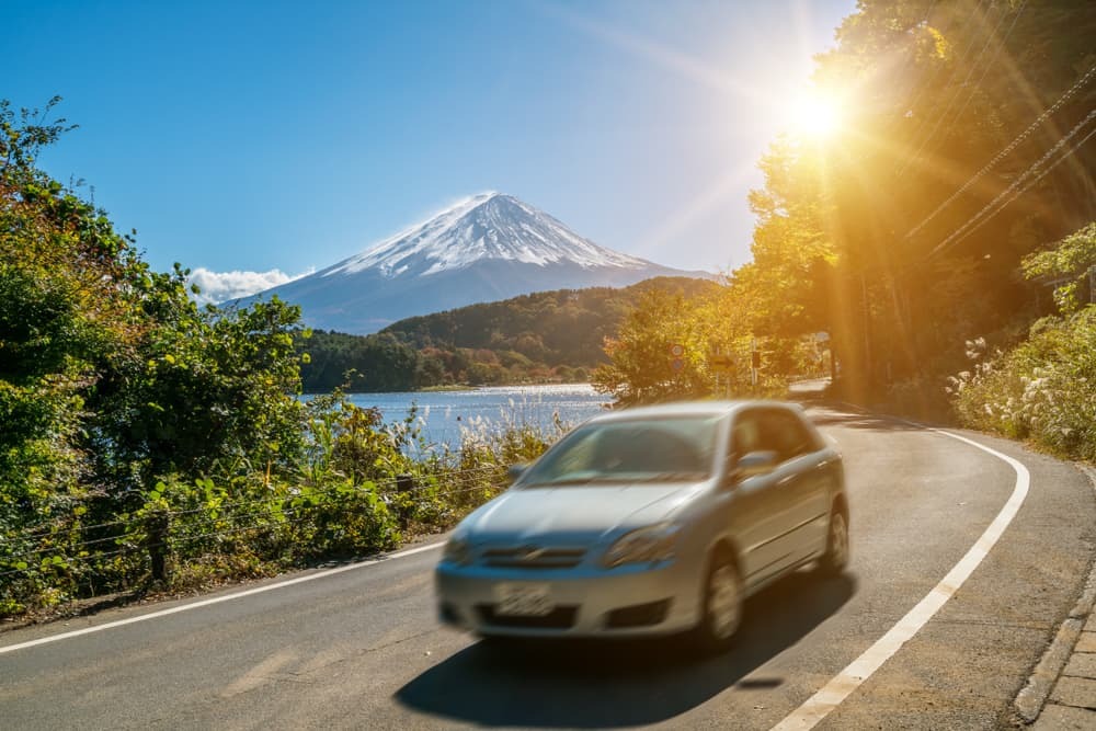 Coche conduciendo cerca del monte Fuji en Japón con desenfoque de movimiento que muestra un movimiento rápido en una carretera en el lago Kawaguchiko