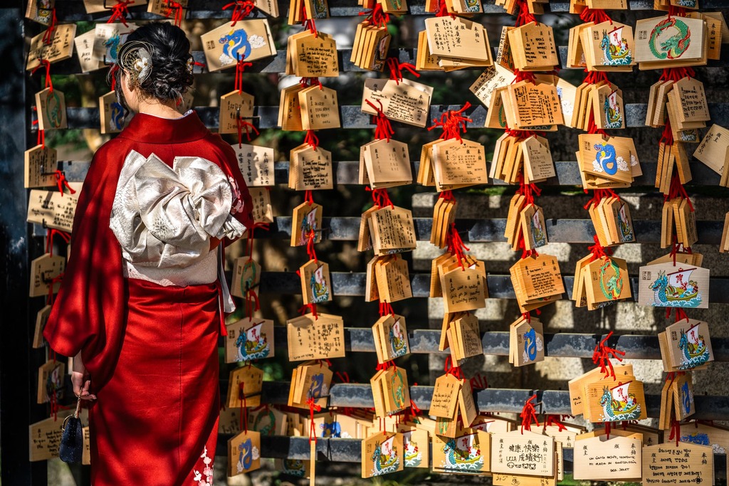 Mujer japonesa leyendo estampas en una tabla de madera en el templo Kiyomizu-dera de Kioto.