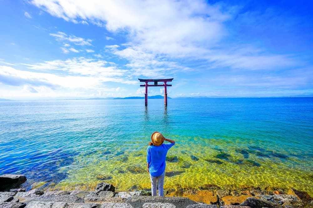 Viajero junto a una puerta torii en el lago Biwa, en la prefectura de Shiga, Japón.
