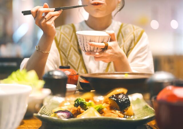 Mujer disfrutando de varias especialidades locales en un restaurante japonés en Tokio