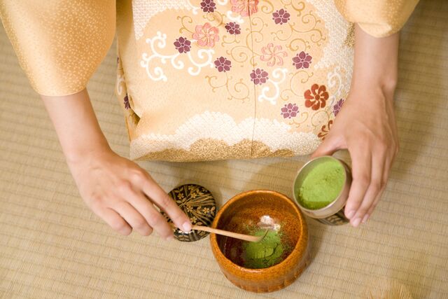 Una mujer vestida con kimono celebrando una ceremonia del té 