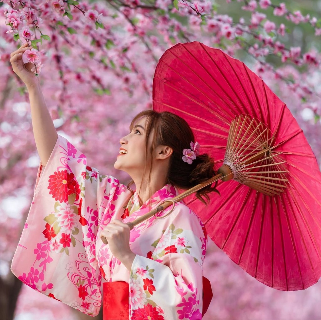 Mujer en kimono disfrutando de los cerezos en flor