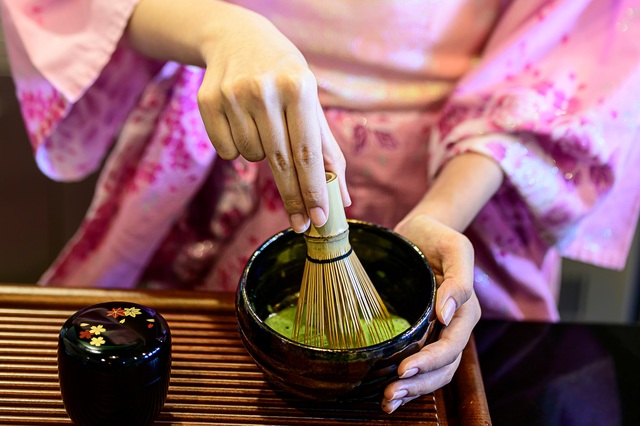 Mujer con kimono preparando té verde japonés