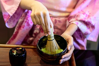 Mujer con kimono preparando té verde japonés